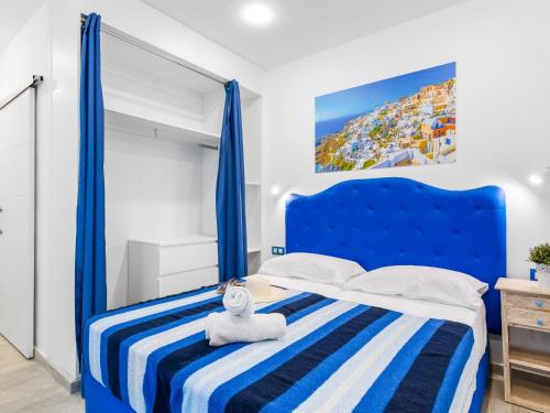 una camera da letto con un letto blu e un orsacchiotto sopra di OKEANOS Eco Guest House a Los Abrigos