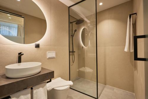 a bathroom with a sink and a glass shower at Bizarre Boutique Hotel in Varna City