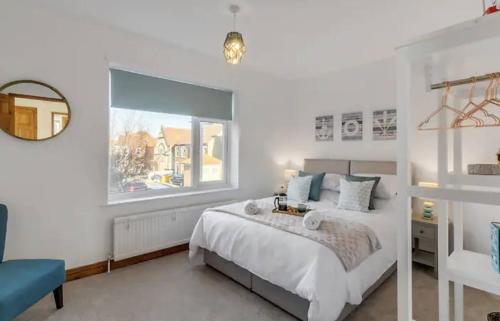 a white bedroom with a bed and a window at Turnstones - Seaside Home - Free Street Parking in Sheringham