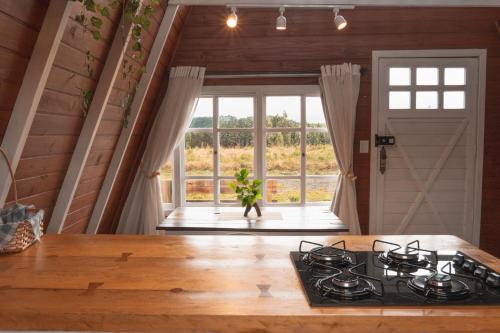 a kitchen with a stove and a large window at Refúgio Fortaleza - Cabana Amora in Cambará