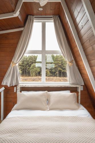 a bed in a room with a large window at Refúgio Fortaleza - Cabana Amora in Cambará
