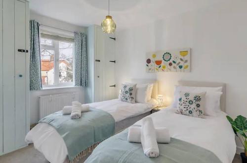 two beds in a room with white walls at Turnstone Retreat - Parking in Sheringham