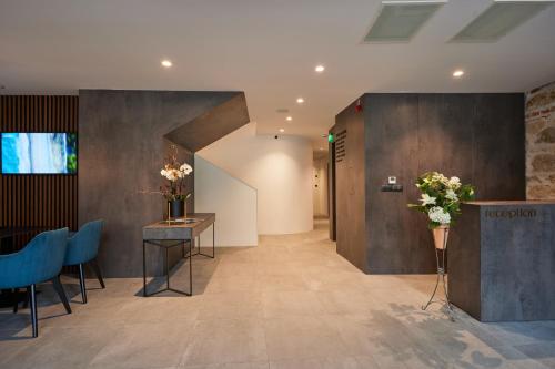 a lobby with blue chairs and a table with flowers at Bizarre Boutique Hotel in Varna City