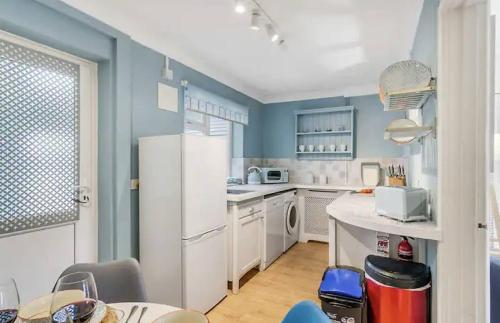a kitchen with blue walls and a white refrigerator at Cosy and Fresh Seaside Home - Parking in Sheringham