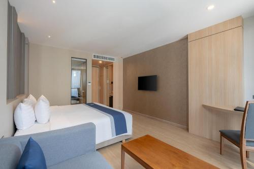 a hotel room with a bed and a couch at Zayn Hotel Bangkok - Airport Link Access in Bangkok