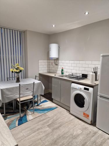 a kitchen with a washing machine and a table at Beautiful Single Bedroom in Liverpool