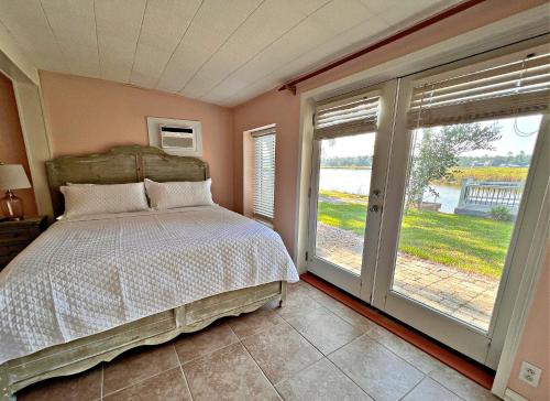 um quarto com uma cama e uma grande janela em Porpoise Pass em Foley