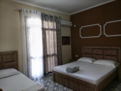 - une chambre avec 2 lits et une fenêtre dans l'établissement Twins Villa Mangalem, à Berat