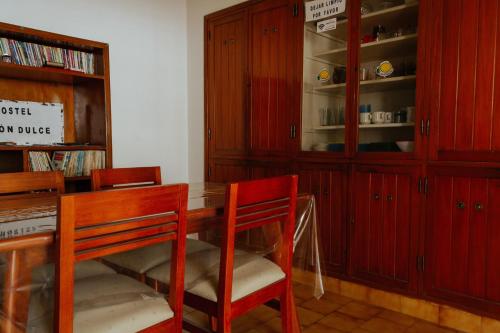 ein Esszimmer mit roten Schränken sowie einem Tisch und Stühlen in der Unterkunft Limón Dulce Hostel in San Fernando del Valle de Catamarca