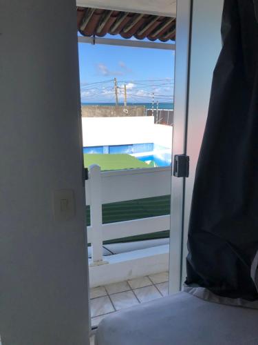 a door to a balcony with a view of a pool at Temporada In Natal - Pousada in Natal