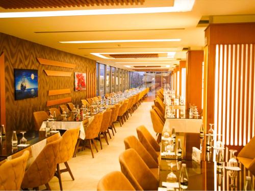une salle à manger avec de longues tables et des chaises jaunes dans l'établissement Granada Hotel, à An Najaf