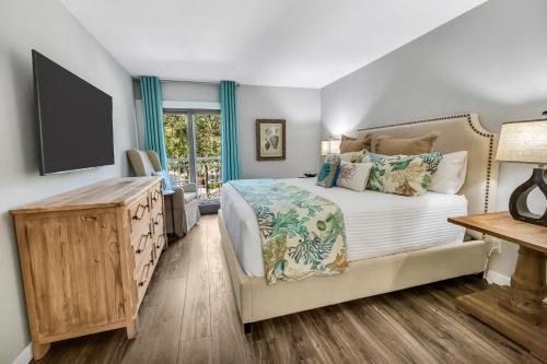 1 dormitorio con 1 cama y TV de pantalla plana en 322 Ocean One, en Hilton Head Island