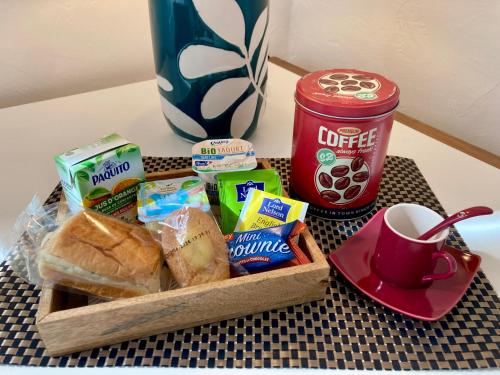 ein Tablett mit einem Korb Brot und einer Tasse Kaffee in der Unterkunft Studio Le Terra - Petit déjeuner inclus 1ère nuit - AUX 4 LOGIS in Foix