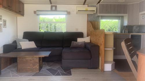 ein Wohnzimmer mit einem Sofa und einem Tisch in der Unterkunft Windy's Guest House - Mobile House in Aljezur