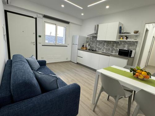 a living room with a blue couch and a table at Thetis Apartments in Furci Siculo
