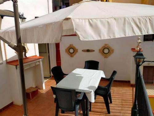 une table et des chaises sous un parasol blanc dans l'établissement Casa vacanza "Il Cortiletto", à Sciacca