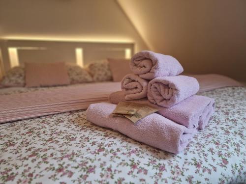 een stapel handdoeken bovenop een bed bij Babyhotel Karolínka, wellness in Vranov nad Dyjí
