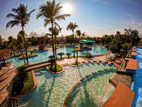 a pool at a resort with palm trees at Blue Tree Thermas de Lins Resort in Lins