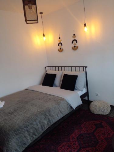 1 dormitorio con 1 cama y luces en la pared en Apartman Nej&Se Ravne, en Visoko