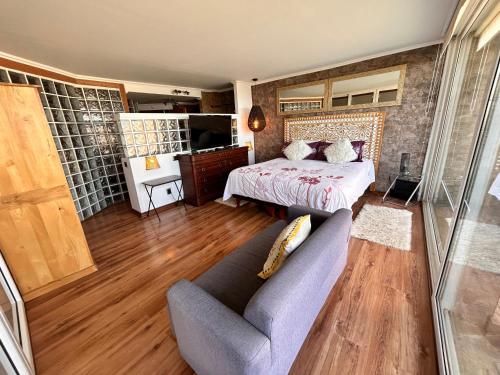 sypialnia z łóżkiem i kanapą w pokoju w obiekcie Pacificsunset Reñaca w mieście Viña del Mar