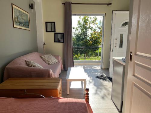sala de estar con sofá y puerta a un balcón en Vivian Philoxenia, en Néa Sampsoús