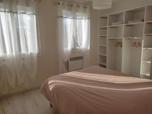 1 dormitorio con 1 cama, ventana y estanterías en Maison dans quartier résidentiel, en Givray
