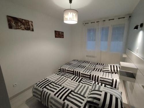 - 2 lits dans une chambre blanche dotée d'un lustre dans l'établissement Maison dans quartier résidentiel, à Givray