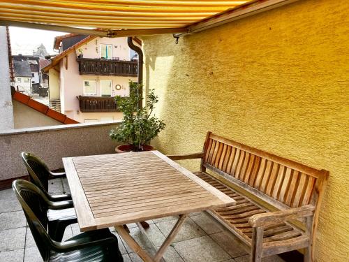 y balcón con mesa y sillas de madera. en Ferienwohnung am Walberla / Fränkische Schweiz, en Kirchehrenbach