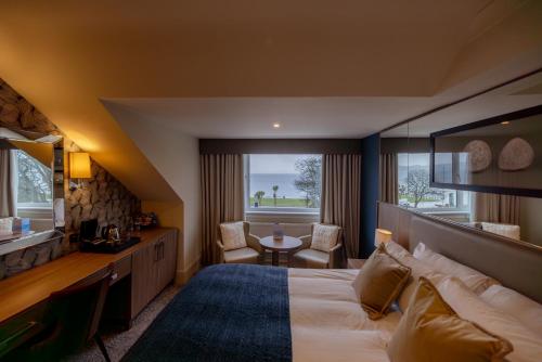 ein Hotelzimmer mit einem großen Bett und einem Tisch in der Unterkunft Brisbane House Hotel in Largs