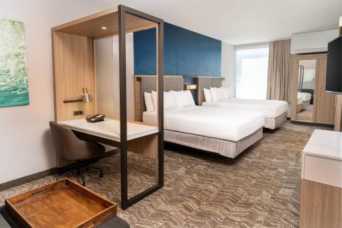 レイクフォレストにあるSpringHill Suites by Marriott Irvine Lake Forestのベッド2台とデスクが備わるホテルルームです。