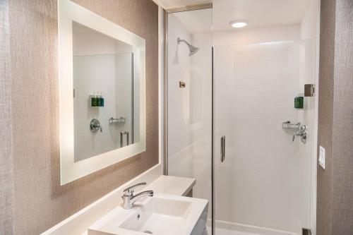 uma casa de banho branca com um lavatório e um chuveiro em SpringHill Suites by Marriott Irvine Lake Forest em Lake Forest