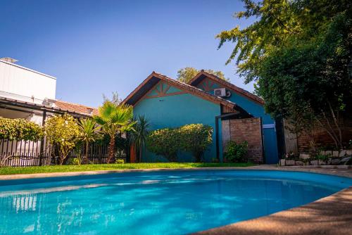 a swimming pool in front of a house at Park Güell House Hotel in Talca