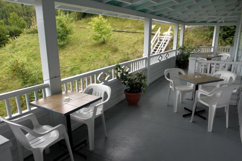 a patio area with a table, chairs, and a balcony at Auberge des Cévennes in LʼAnse-Saint-Jean