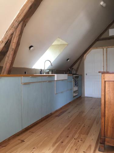 una cocina en un ático con suelo de madera en Gîte la Luchette - petit village médiéval de la Somme, en Lucheux
