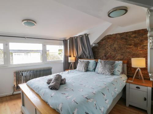 a bedroom with a bed with a blue comforter at Pebble Bay in Brixham