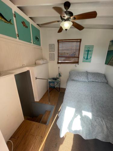 a bedroom with a bed and a ceiling fan at Updated houseboat on the river! in Fort Lauderdale