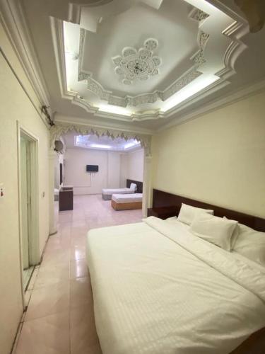 a bedroom with a large bed and a living room at فندق السمان in Al Madinah