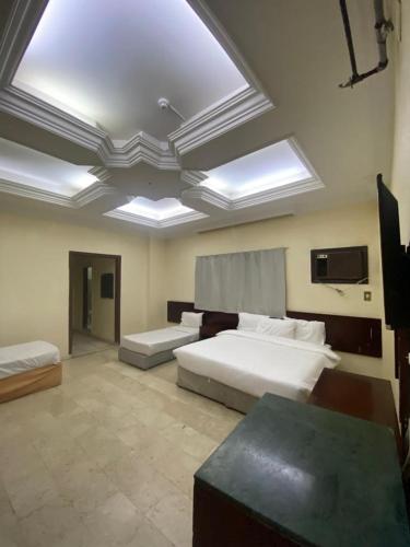 a large bedroom with a large bed and a tv at فندق السمان in Al Madinah