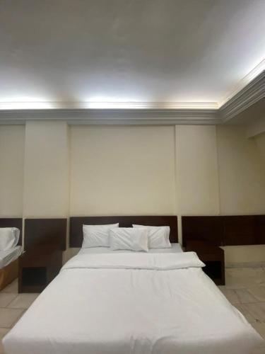 a bedroom with a large white bed in it at فندق السمان in Al Madinah