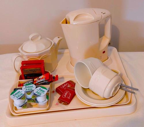 a white blender on a tray with tea packets at Enniskeen Country House Hotel in Newcastle