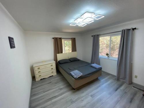 um quarto com uma cama, uma cómoda e uma janela em Scenic view villa near Yosemite em Groveland