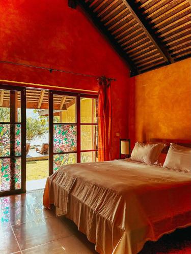a bedroom with a large bed with red walls at Villa Mitirapa in Tohautu