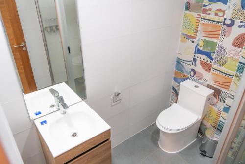 a bathroom with a toilet and a sink and a mirror at Park Güell House Hotel in Talca