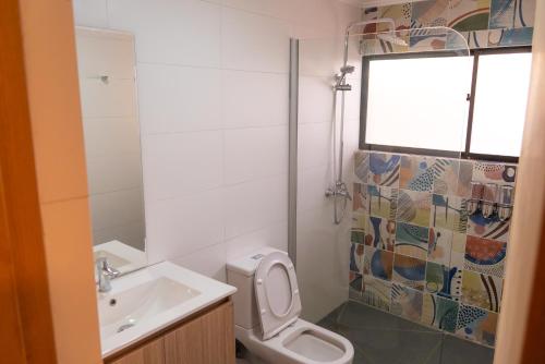 a bathroom with a toilet and a sink at Park Güell House Hotel in Talca