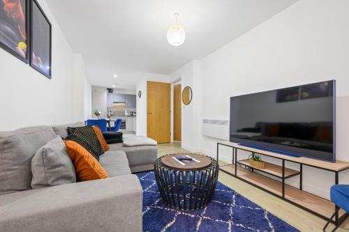 a living room with a couch and a large flat screen tv at Stylish & Spacious Salford Quays one bedroom high floor apartment with balcony in Manchester