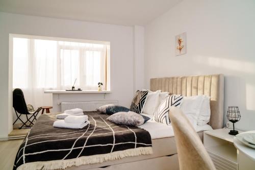 um quarto branco com uma cama com almofadas em Studio Lounge em Craiova