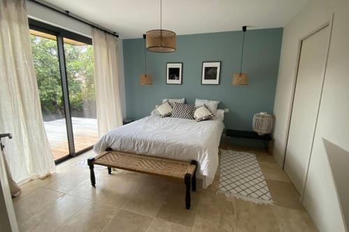 une chambre avec un lit et une grande fenêtre dans l'établissement Villa contemporaine à 500 mètres de la plage !, à Calcatoggio