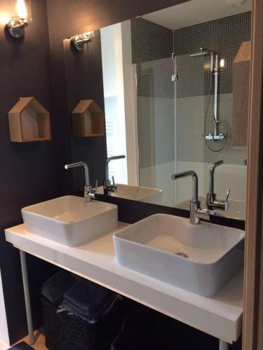 une salle de bain avec deux lavabos et un miroir dans l'établissement Villa contemporaine à 500 mètres de la plage !, à Calcatoggio