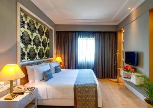 Pokój hotelowy z dużym łóżkiem i telewizorem w obiekcie Hotel Seven Inn (R S Gorup Near Delhi Airport) w Nowym Delhi