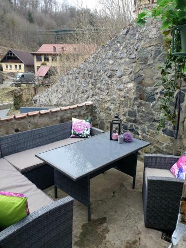 a table and two chairs and a stone wall at Kreuztal 3 in Neuwerk